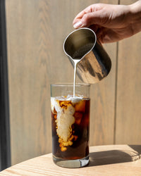 Adding cream to a cold brew coffee on a hot day | Equator Coffees