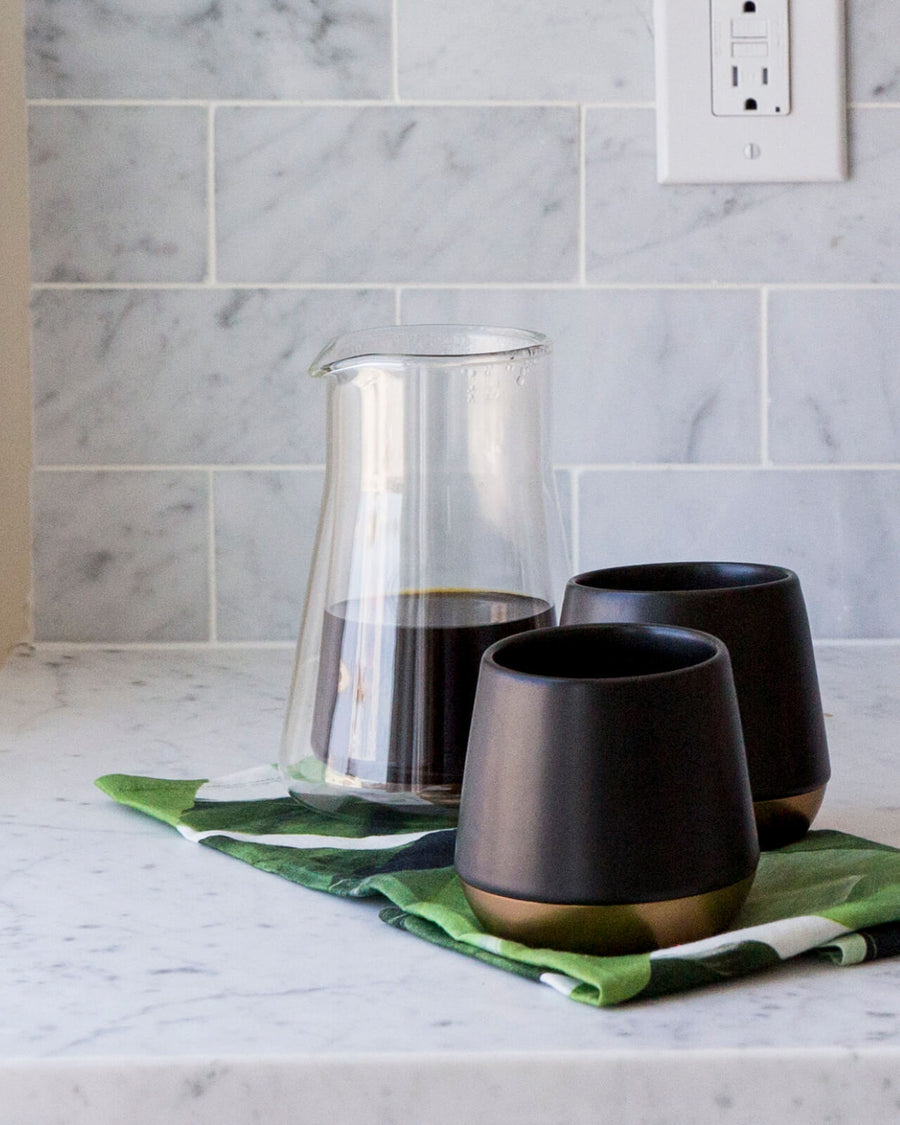 Fellow Stagg Double Wall Carafe | Fellow Coffee Carafe | Fellow Coffee Pitcher is ready to serve with two black mugs | Equator Coffees